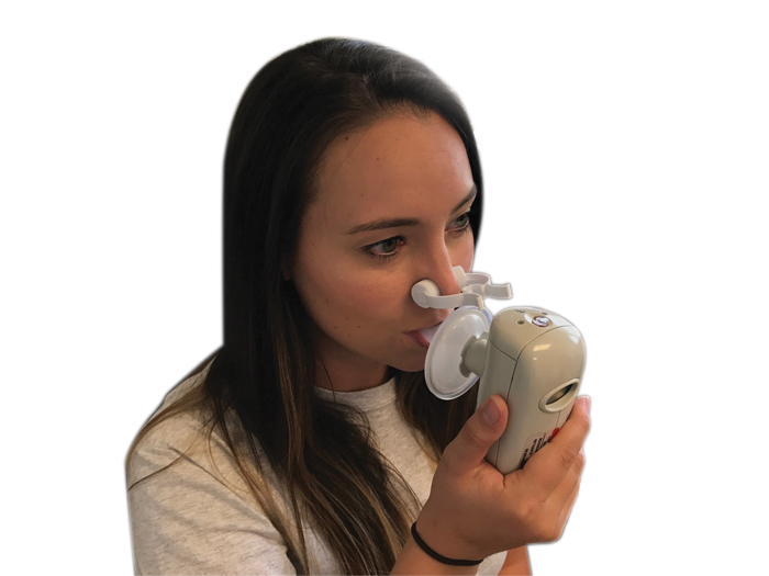 A person using a handheld indirect calorimetry device, breathing into a mouthpiece connected to a small sensor unit held in the hand.