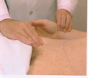 An examiner's hand pressing into the groin of a supine patient, with the other hand held beside it.